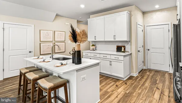 a kitchen with a sink a stove a refrigerator and white cabinets