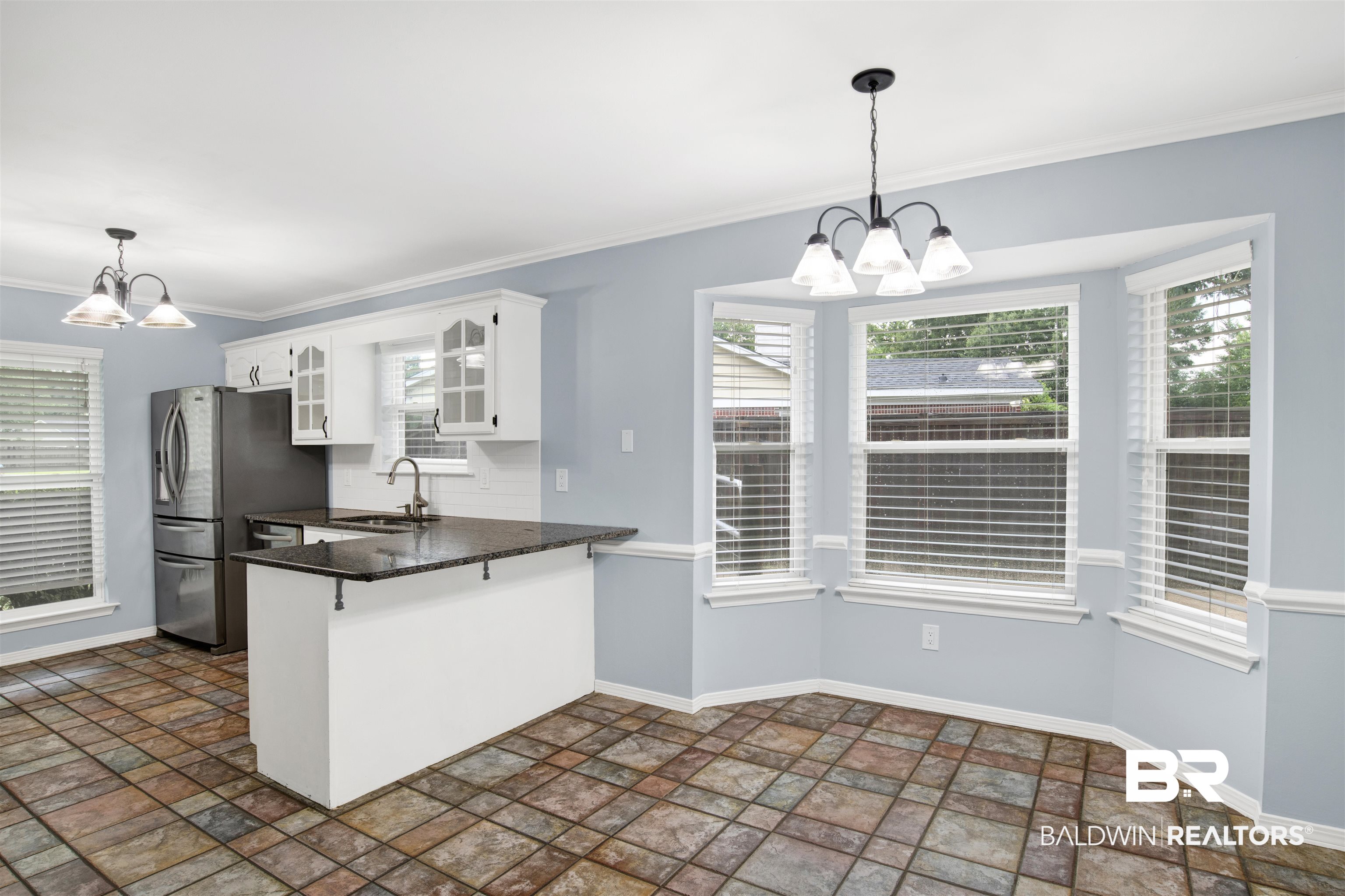 3011 Olde Gate Road Mobile, AL 36695 - Photo 17 of 35 Kitchen with a chandelier, stainless steel fridge, a peninsula, white cabinets, and ornamental molding