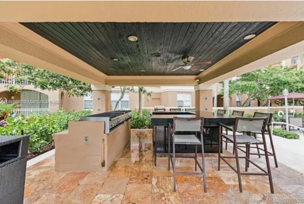 a view of a patio with table and chairs with wooden floor and fence