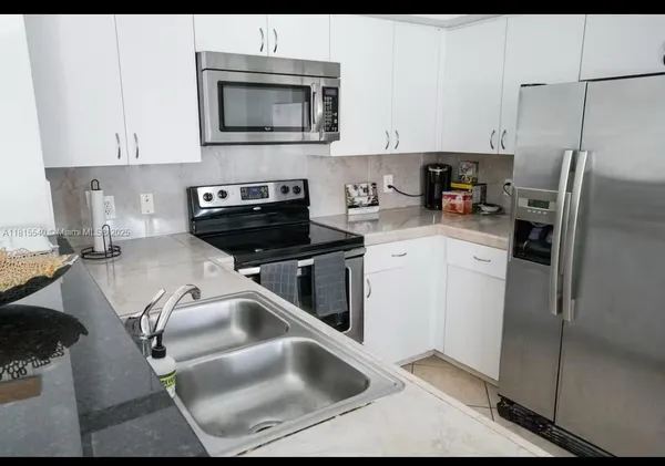 a kitchen with a sink cabinets and stainless steel appliances
