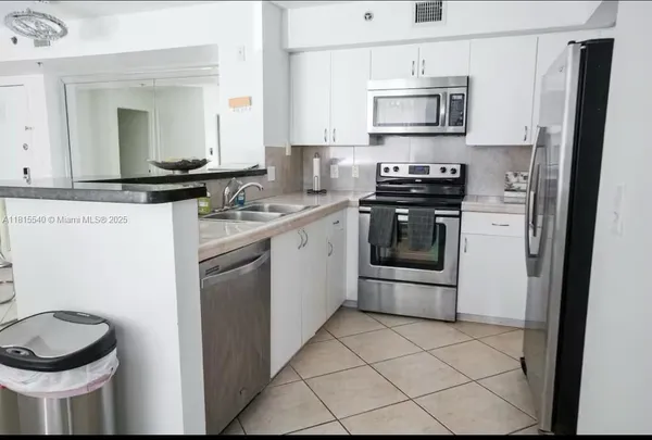 a kitchen with stainless steel appliances a stove a sink and a microwave