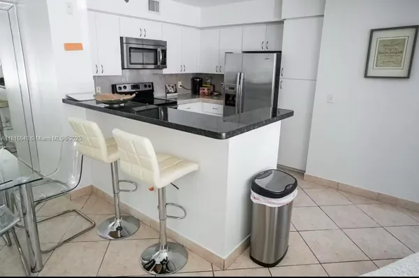 a kitchen with stainless steel appliances granite countertop a sink a stove a refrigerator and cabinets