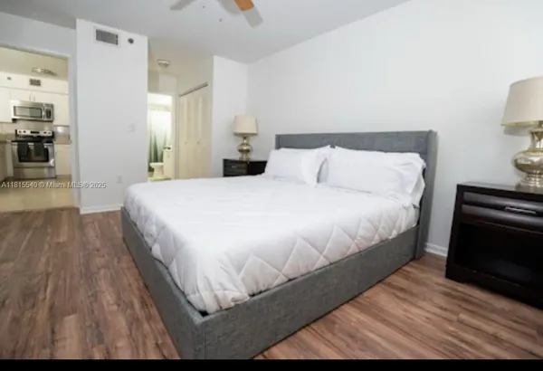 a bedroom with a bed and wooden floor