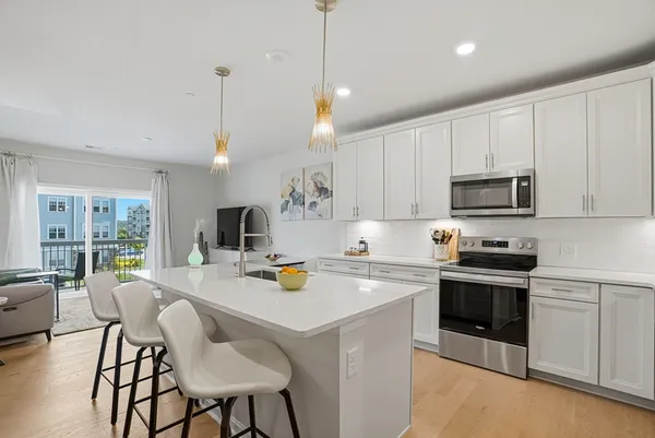 a kitchen with a sink a stove and chairs