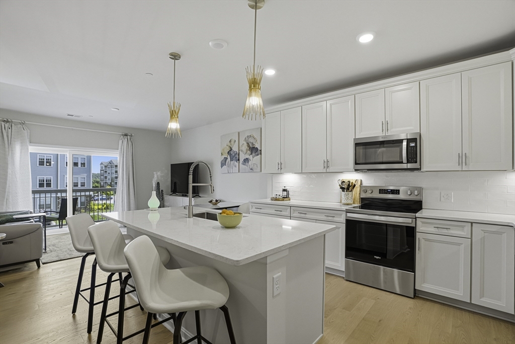 2 Codman Way, Unit 2203 Westborough, MA 01581 - Photo 1 of 36 a kitchen with a sink a stove and chairs