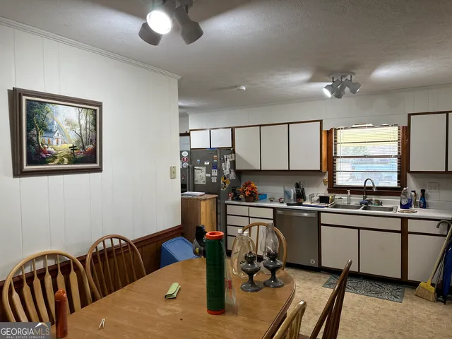 a kitchen with stainless steel appliances granite countertop a sink dishwasher a stove a refrigerator with wooden cabinets and floor