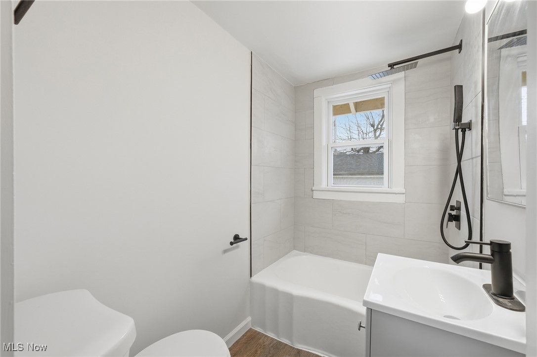 7911 Snow Road Parma, OH 44129 - Photo 18 of 44 Bathroom with vanity, shower / bathtub combination, and dark wood finished floors