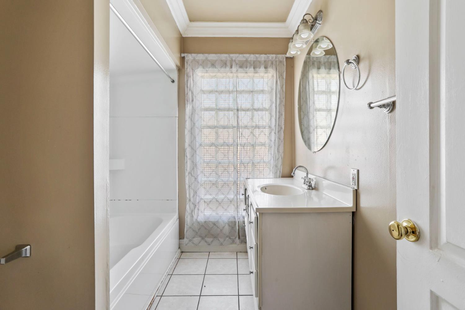 916 Elm Avenue Modesto, CA 95351 - Photo 24 of 52 25. Bathroom vanity view Clean, practical, and bright — this bathroom keeps things simple with a full tub/shower setup and usable vanity space.