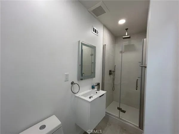 a bathroom with a shower a sink and mirror