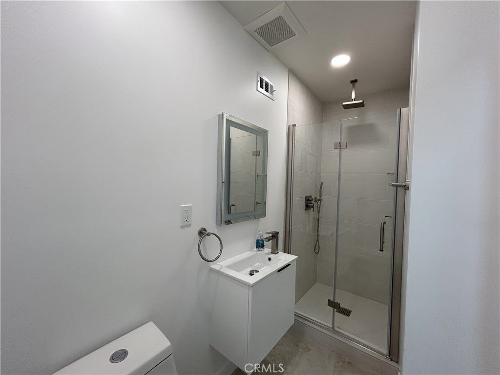 10363 Commerce Avenue Tujunga, CA 91042 - Photo 12 of 51 a bathroom with a shower a sink and mirror