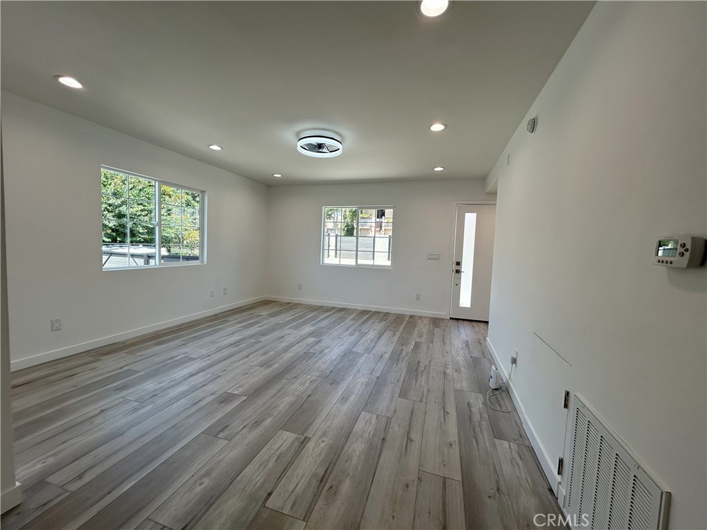 10363 Commerce Avenue Tujunga, CA 91042 - Photo 15 of 51 an empty room with wooden floor and windows