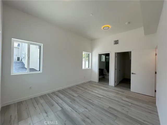 an empty room with closet and windows