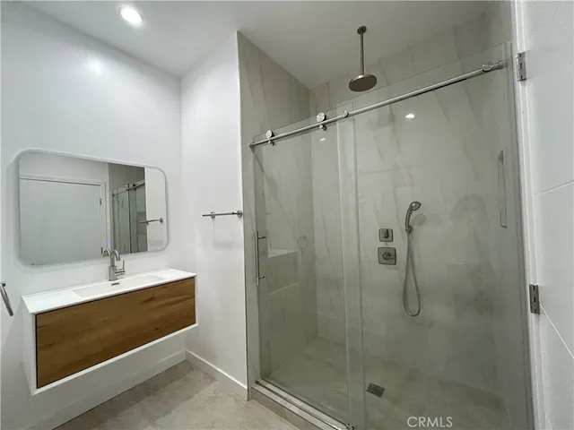 a bathroom with a shower sink and mirror