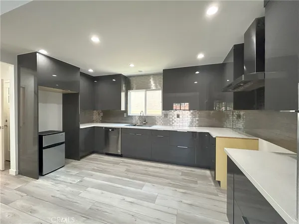 a large kitchen with stainless steel appliances kitchen island granite countertop a refrigerator and a sink