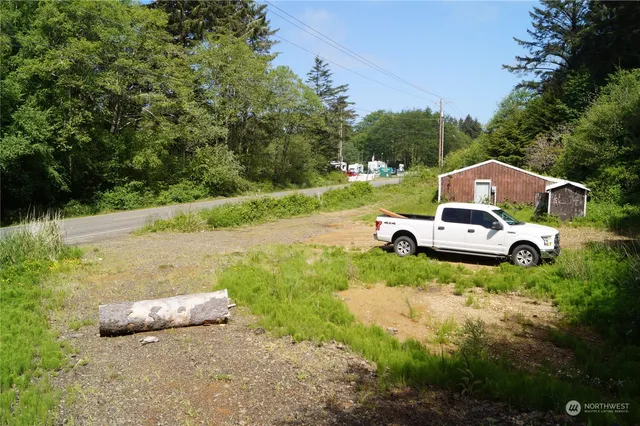 a white house with a yard and car parked
