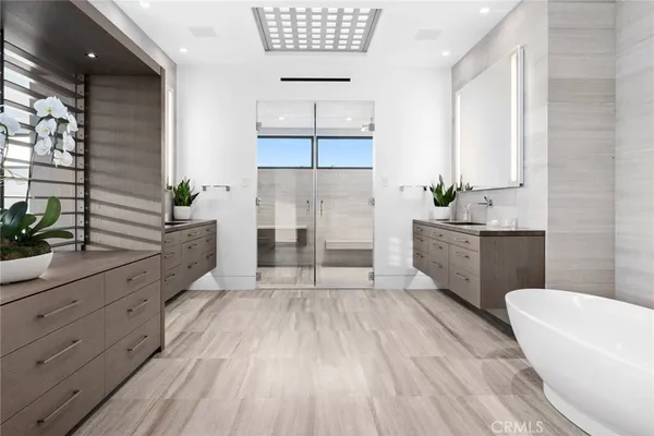 a spacious bathroom with double vanity a mirror a bathtub and a shower