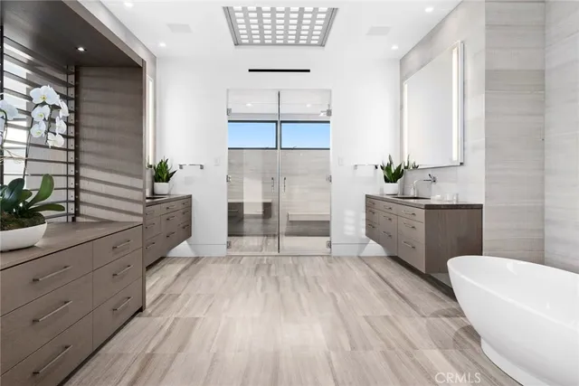 a spacious bathroom with double vanity a mirror a bathtub and a shower