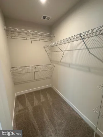 an empty room with a ceiling fan and windows