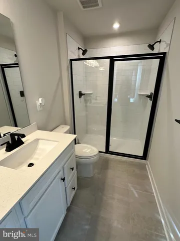 a bathroom with a double vanity sink toilet and shower