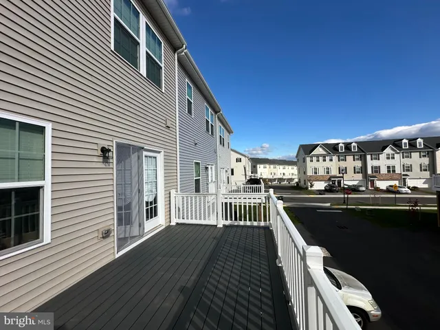a view of a balcony with wooden floor and outdoor seating