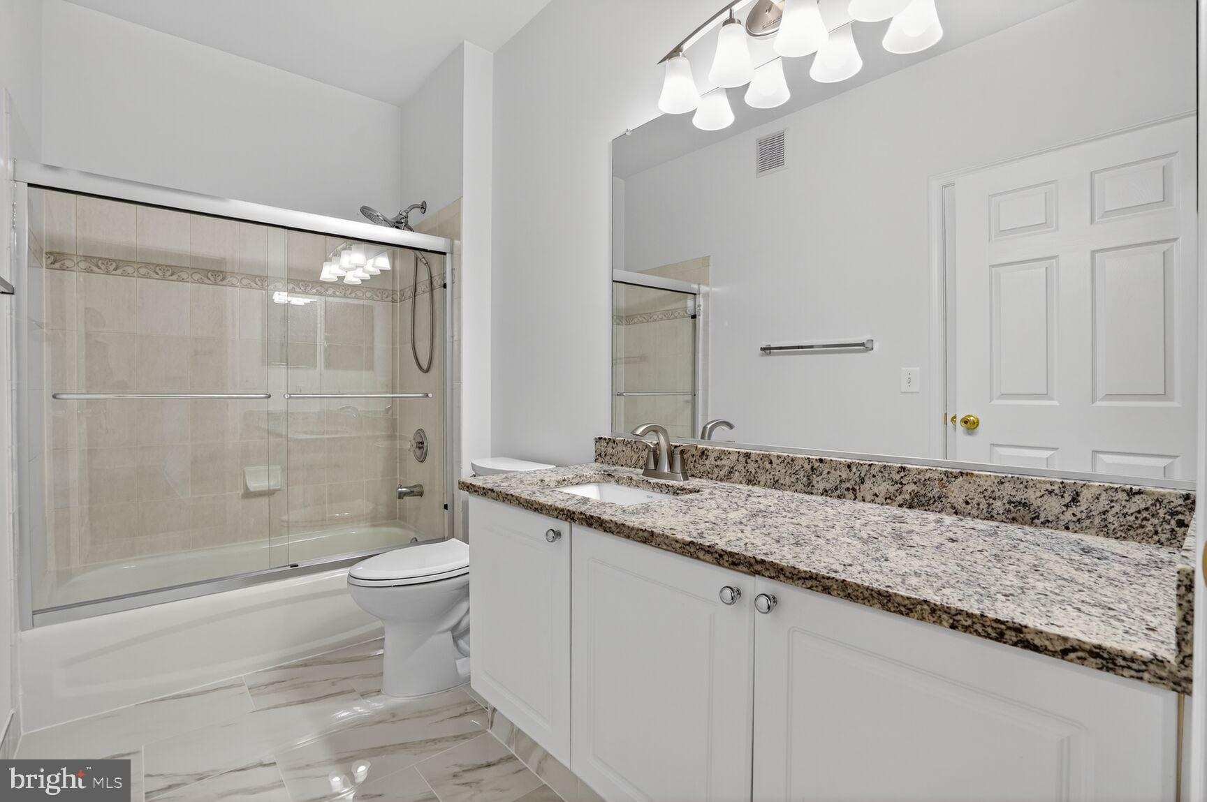 4300 Cannon Ridge Court, Unit 14 Fairfax, VA 22033 - Photo 16 of 23 a bathroom with a granite countertop sink a toilet a mirror and shower