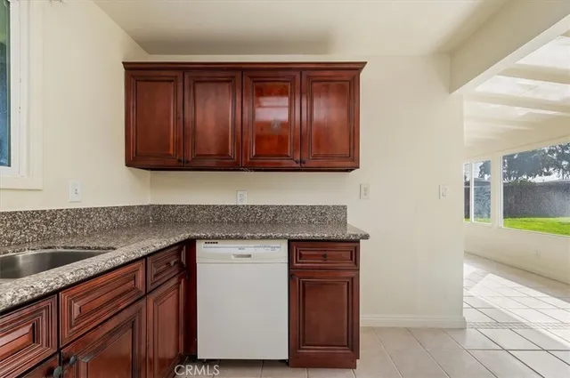 a kitchen with granite countertop wooden cabinets and a sink