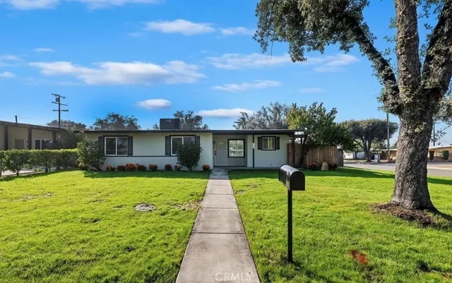 a front view of a house with a yard and trees