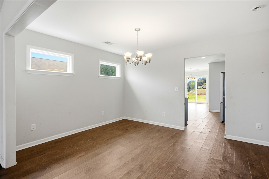 245 Maple Grove Road Seneca, SC 29678 - Photo 7 of 40 Bright and inviting dining area features warm wood flooring and an elegant overhead light fixture.