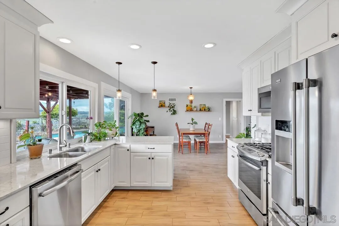 13415 Pequot Drive Poway, CA 92064 - Photo 18 of 63 a kitchen with stainless steel appliances a sink a stove a refrigerator cabinets and wooden floor