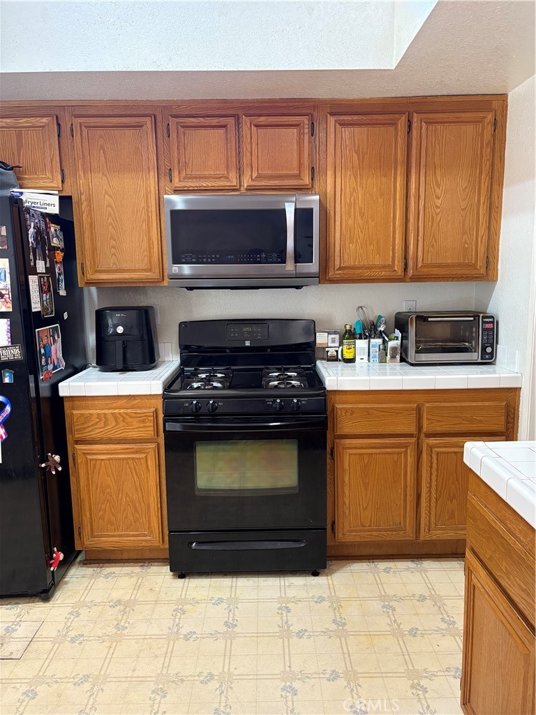 133 Cannon Road Riverside, CA 92506 - Photo 5 of 32 a kitchen with stainless steel appliances granite countertop a stove a sink and a microwave