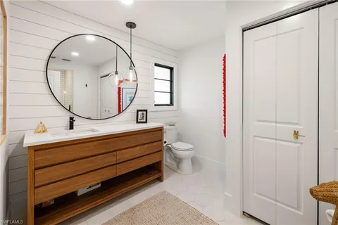 a bathroom with a sink mirror and toilet