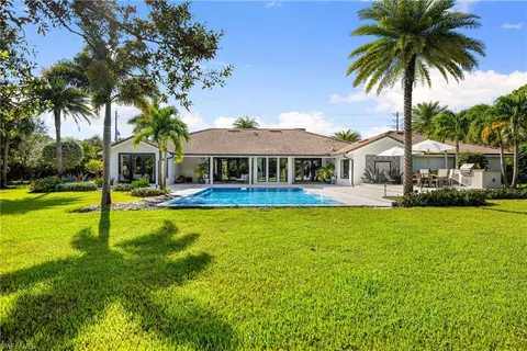 a front view of a house with swimming pool and porch with furniture