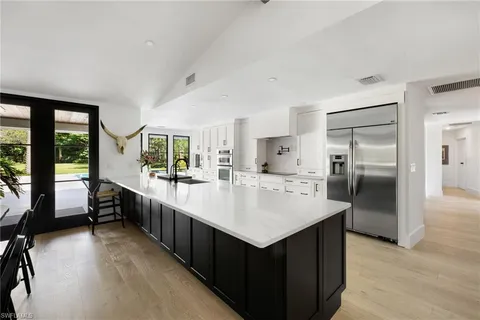 a large kitchen with kitchen island a sink and a refrigerator