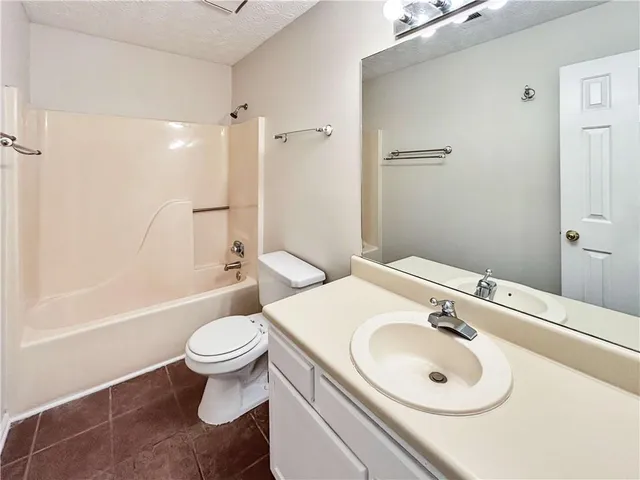 a bathroom with a sink toilet mirror and shower