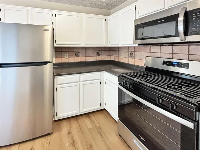 a kitchen with a refrigerator stove and microwave