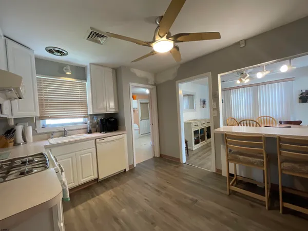 a kitchen with a table chairs refrigerator and cabinets