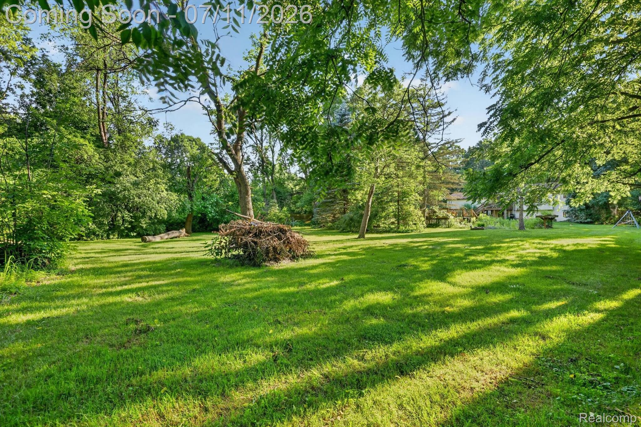 4430 North Center Road Flint, MI 48506 - Photo 44 of 49 Expansive green lawn surrounded by mature trees, featuring dappled sunlight