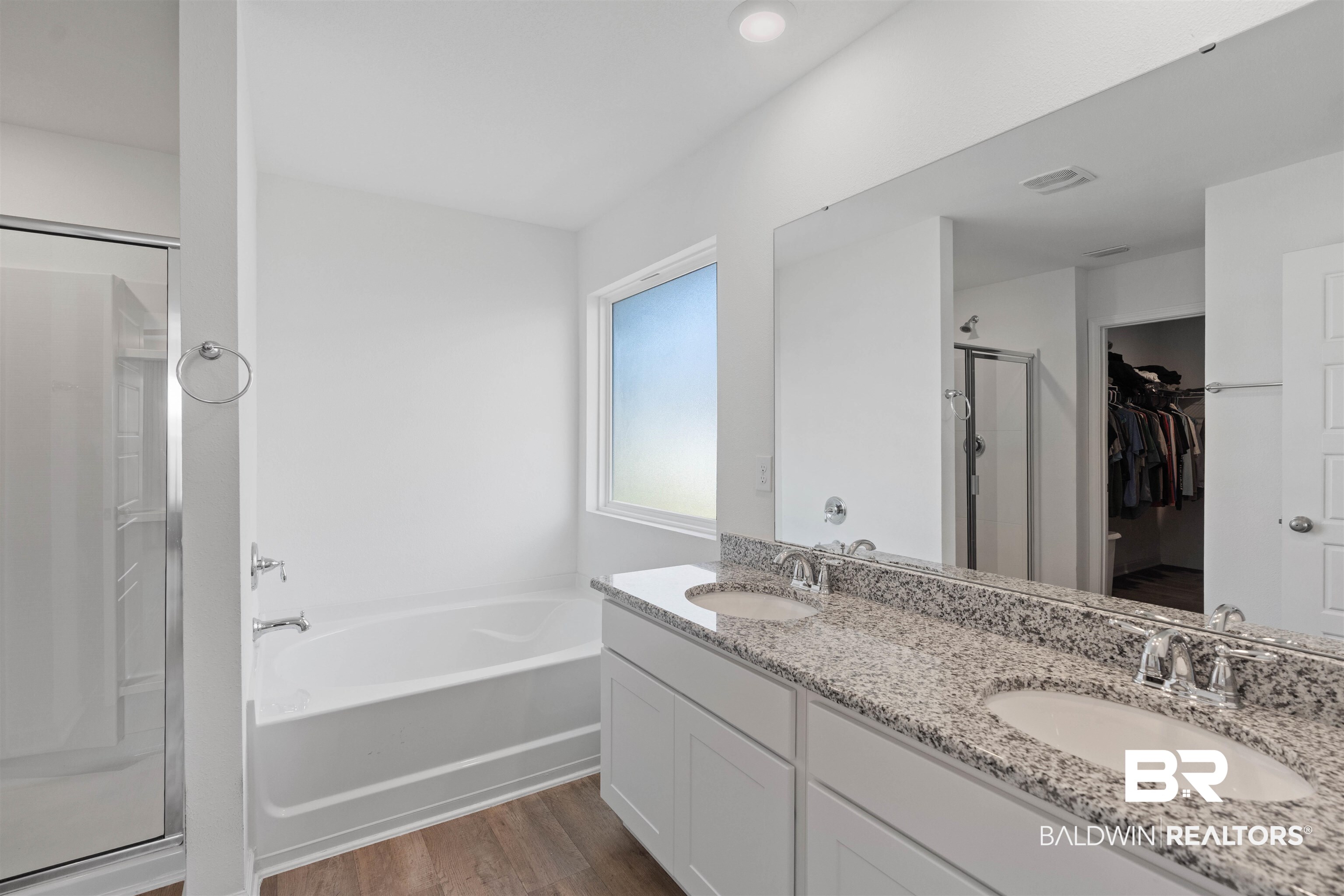 15030 Forsythia Loop Silverhill, AL 36576 - Photo 18 of 33 Full bath featuring a shower stall, a walk in closet, a bath, dark wood-type flooring, and double vanity