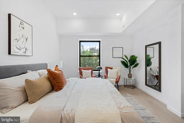 a bedroom with a large bed and a potted plant