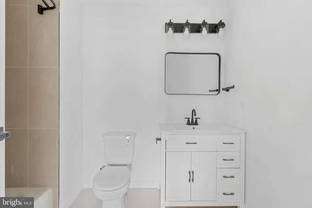 a bathroom with a sink a toilet and a mirror