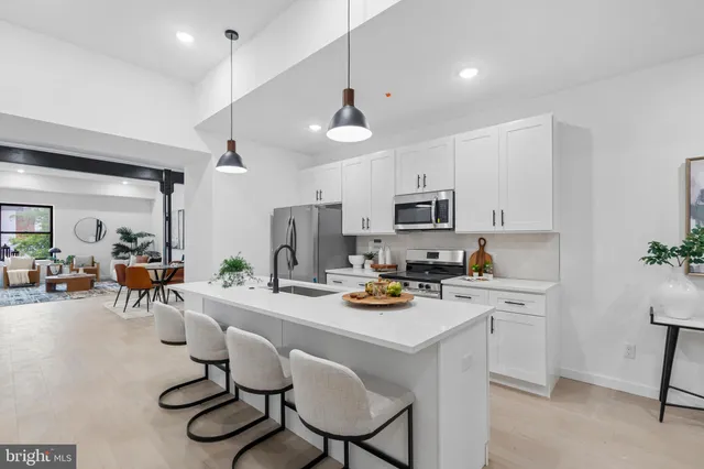 a kitchen with stainless steel appliances a stove a table and chairs in it