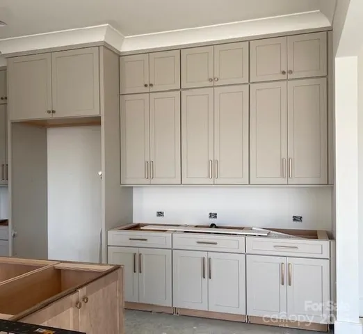 a kitchen with granite countertop white cabinets and sink