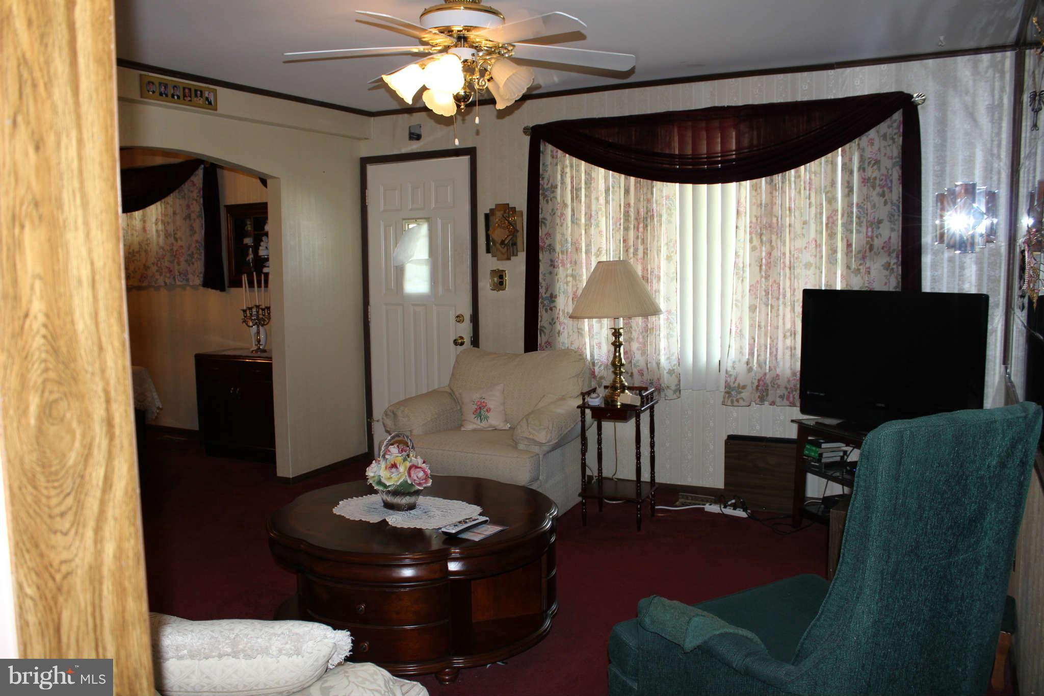 1319 North Point Road Dundalk, MD 21222 - Photo 3 of 24 a living room with furniture a chandelier and a flat screen tv
