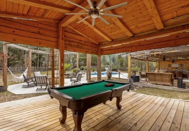 a living room with patio furniture and wooden floor