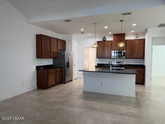 a kitchen with stainless steel appliances a refrigerator and a stove top oven