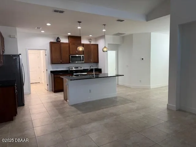 a kitchen with stainless steel appliances granite countertop a sink a stove and a refrigerator