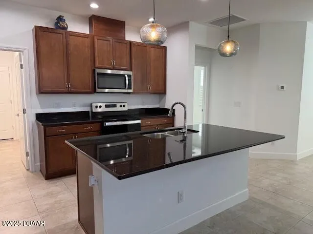 a kitchen with stainless steel appliances granite countertop a sink a stove top oven a counter space and cabinets