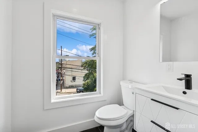 a bathroom with a sink a toilet and a window