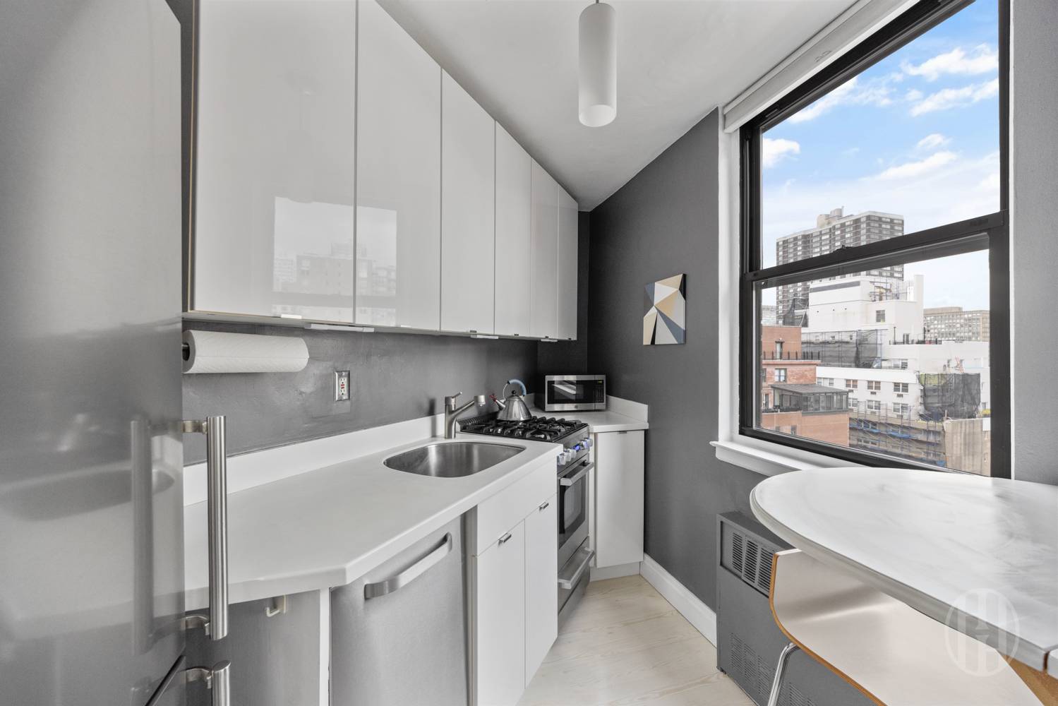 225 East 36th Street, Unit 14M Manhattan, NY 10016 - Photo 4 of 8 a kitchen with a sink a stove and white cabinets