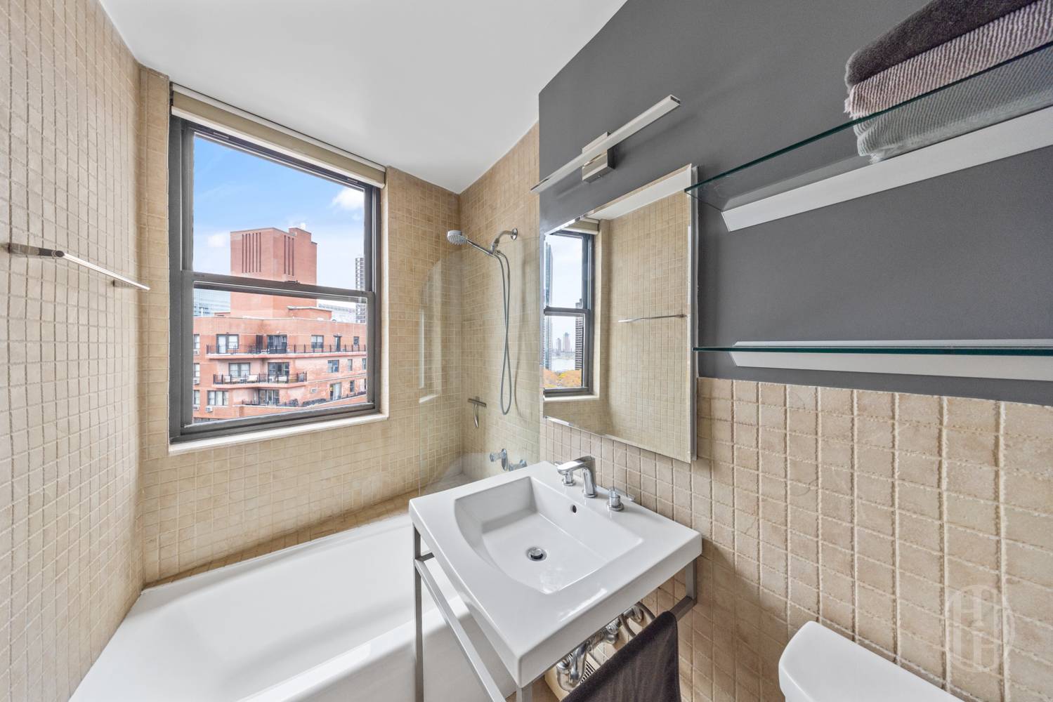 225 East 36th Street, Unit 14M Manhattan, NY 10016 - Photo 5 of 8 a bathroom with a sink vanity mirror and a bathtub